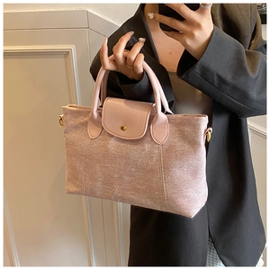 Dettaglio della borsa Boston rosa con finiture dorate e manici superiori arcuati