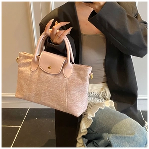 Dettaglio della borsa tote rosa in tela con patta in pelle e chiusura con bottone a scatto