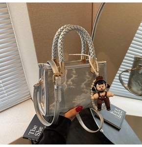 Silver patent leather handbag with braided handle, gold hardware and doll charm