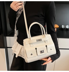 Detail of off-white retro briefcase with silver twist-lock and multi-pocket cargo design