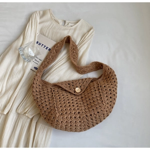 Detail of hand-woven brown crochet bag showing honeycomb texture and wood button