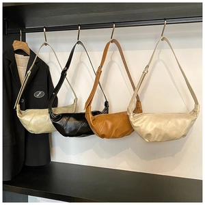 Detail view of stylish quilted faux leather dumplings bags in various colors on a rack