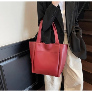 Detail of a large matte wine red tote bag featuring a front pocket for office commute