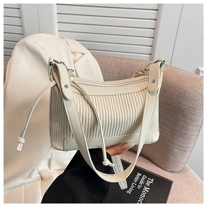 Détail du sac à bandoulière crème avec texture plissée et fermeture éclair argentée