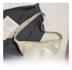 Detail of the stitching and adjustable wide strap on the cream half-moon bag