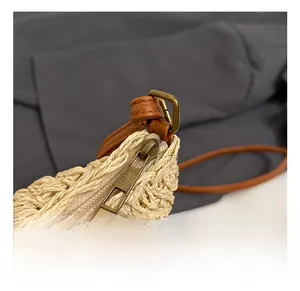 Close-up of the vintage bronze zipper and beige woven texture of this bucket bag
