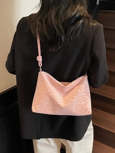 Grand sac cabas rose avec texture géométrique en relief porté à l'épaule par un mannequin