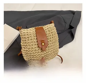 Detailed view of woven beige bucket bag with brown leather strap on gray blazer