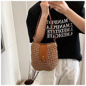 Close-up of handwoven bucket bag featuring a vintage metal buckle and brown leather strap