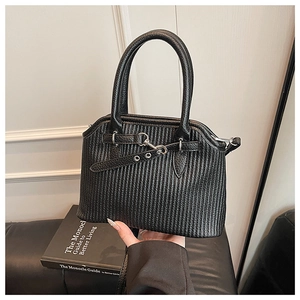 Detail der schwarzen Handtasche aus Falten-Kunstleder mit silbernen Metallschnallen und Griffen