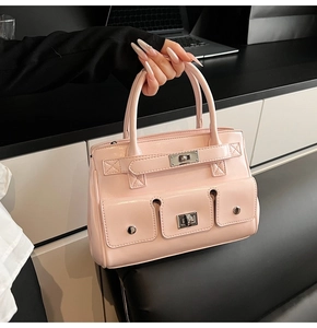 Detail view of pink leather handbag with multi-pockets and classic twist lock buckle