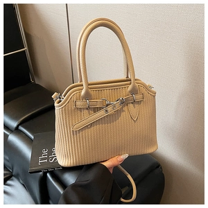 Detail der beige gefalteten Leder-Tragetasche mit Silberbeschlägen und Doppelgriffen