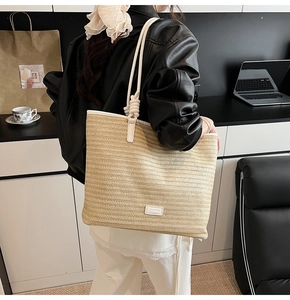Detail of woven tote bag featuring thick rope handles and stylish knot design on the side