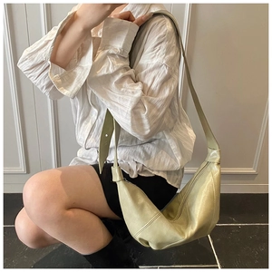 Pale green crescent dumpling bag shown on shoulder for a lightweight minimalist aesthetic