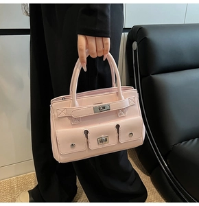 Detailed shot of pink multi-pocket handbag with silver turn-lock and leather texture