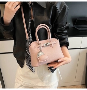 Borsa a mano in pelle rosa grana litchi con chiusura a scatto e ciondolo a cuore