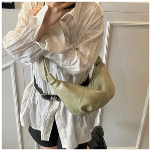 Macro shot of light green oversized leather half-moon bag with elegant pleat textures