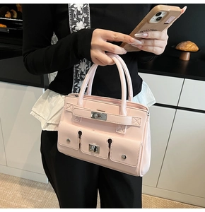Detail of light pink patent leather handbag with silver metallic locks and cargo pockets