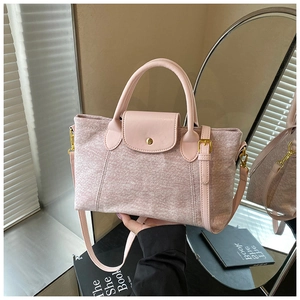 Dettaglio della borsa tote rosa in tela con patta in pelle e fibbia metallica dorata
