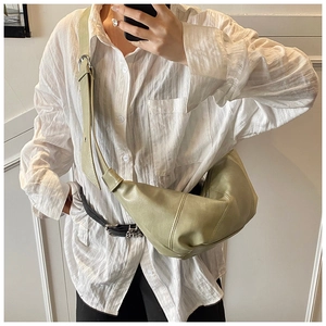 Detail of light green soft leather croissant bag with adjustable strap and stitching