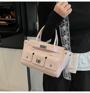 Detail of light pink tote bag with functional front pockets and silver twist lock closures