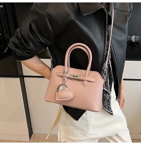 Borsa a conchiglia rosa in pelle testurizzata con ciondolo a cuore su modella