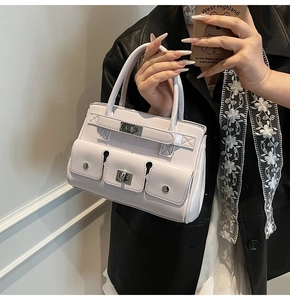 Detail of lavender leather handbag featuring three front pockets and silver metal buckle