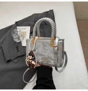 Detail of silver marble textured handbag with braided handle and pearl charm