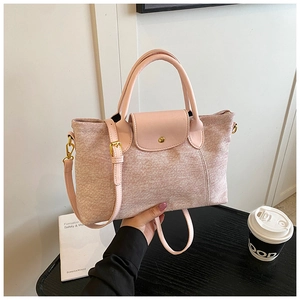 Dettaglio borsa tote rosa chiaro in tela con manici in pelle e fibbia metallica rotonda