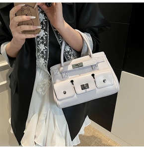 Detail of the light pink leather handbag with silver metal buckles and three front pockets