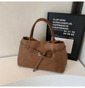 Detail of high-density nylon tote bag with leather buckle and metallic silver ring