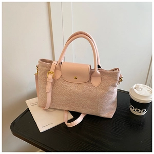 Dettaglio borsa tote in tessuto rosa e beige con manici in pelle e fibbia in metallo oro