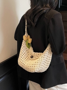 Chic beige crochet hollow knit shoulder bag styled with a black blazer for casual wear