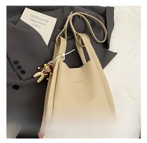 Dettaglio borsa in pelle beige con stampa Fashion e ciondolo a fumetti con perline