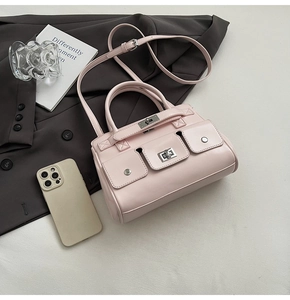 Pale pink glossy leather handbag with triple front pockets and metal twist locks