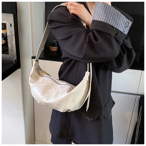 Detail shot of a creamy white crescent hobo bag made of soft leather for daily commute