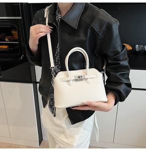 Dettaglio della chiusura a scatto argento e pelle martellata sulla borsa beige