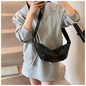 Close-up of black PU leather dumpling bag with soft pleats and wide shoulder strap