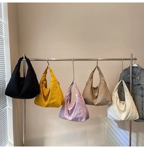 Gros plan de sacs hobo en nylon colorés suspendus en noir, jaune, violet, kaki et blanc