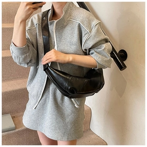 Detail view of the black leather hobo bag showing the unique pleated texture and shoulder strap