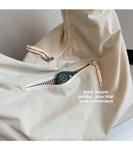 Détail de la poche zippée arrière d'un cabas beige avec doublure intérieure rayée