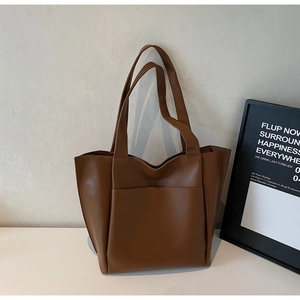 Detailed view of dark brown leather tote bag with large front pocket for office commute