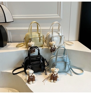 Detail of shell bags in yellow, white, black and blue with cute teddy bear charms