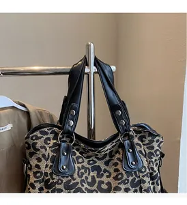 Detail of leopard print tote bag featuring sturdy PU handles and decorative silver rivets