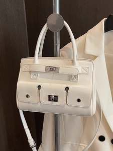 Elegant cream white top handle bag with belt buckle clasp and crossbody strap