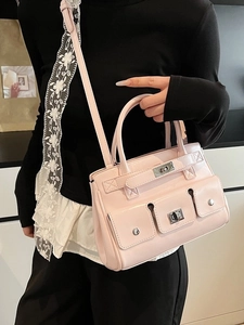 Chic pink glossy leather handbag with lock pockets, convertible to a crossbody bag