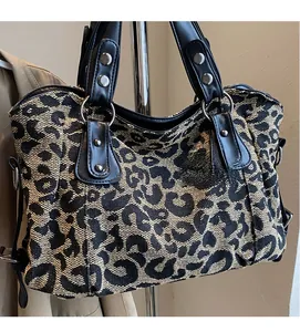 Close-up of leopard print jacquard fabric and black faux leather strap with silver rivets