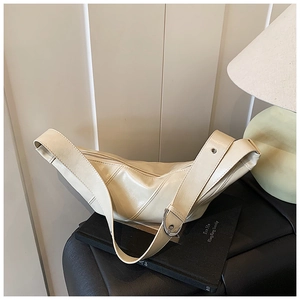 Detailed shot of off-white crescent bag with silver buckle and smooth faux leather