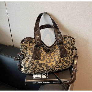Close-up of leopard print canvas bag with leather reinforcement straps and silver rivets