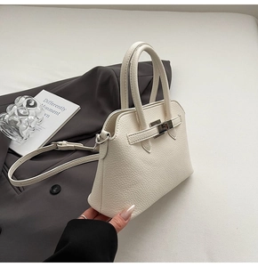 Dettaglio della borsa a mano bianca in pelle martellata con chiusura a scatto in metallo